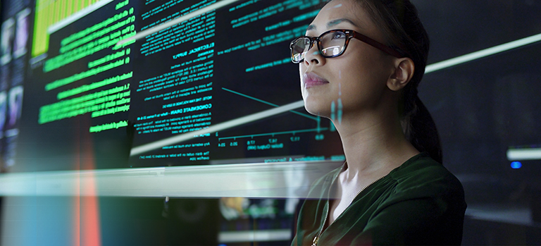 Spécialiste IT travaillant devant écran avec code vert – développement logiciel et cybersécurité